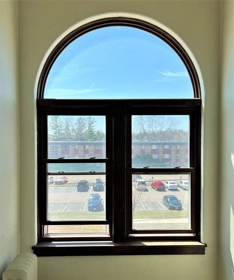 an arched window with a view of a parking lot